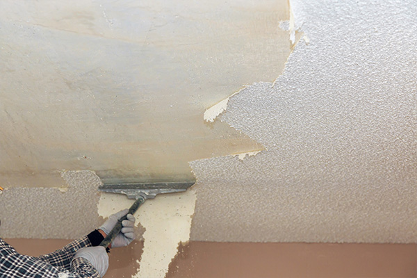 Image of a popcorn ceiling being scraped