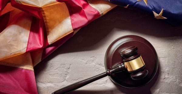 American flag behind a courtroom gavel, symbolizing legal support for veterans